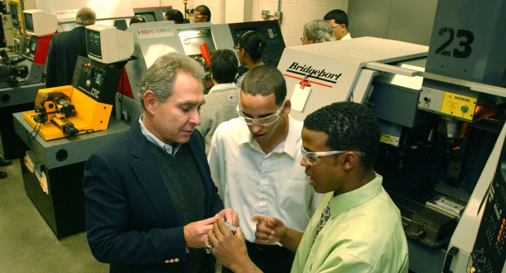 11-7-2006 - Holyoke Dean Technical High school CNC machine shop sophmore students Ruben Marquez and Javier Rodriguez show off the indicator fixture made in the shop to Mark E. Dilorenzo, president of Tell Tool Inc. in Westfield. CUTLINE: 11/12/06 - Machine-shop sophomores Ruben Marquez and Javier Rodriguez, at right, show an indicator fixture made in Holyoke's Dean Technical-Vocational High School to Mark E. DiLorenzo, president of Westfield's Tell Tool Inc., right.